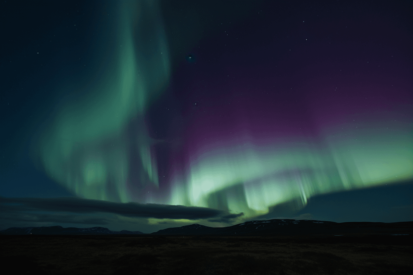 A photograph of the Northern Lights, with the green and purple hues swirling in the night sky.